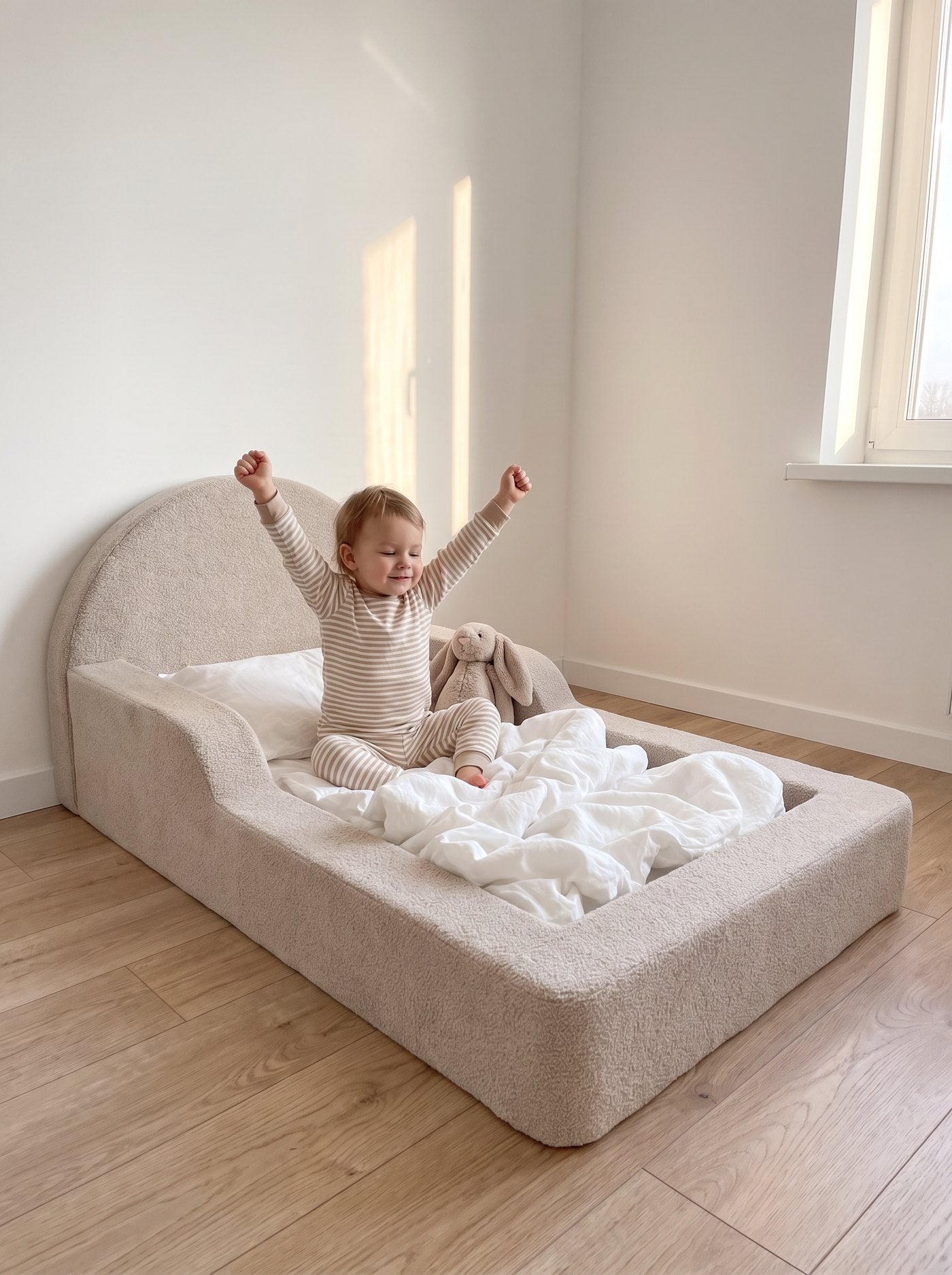 Kind wacht fröhlich im Bodenbett auf
